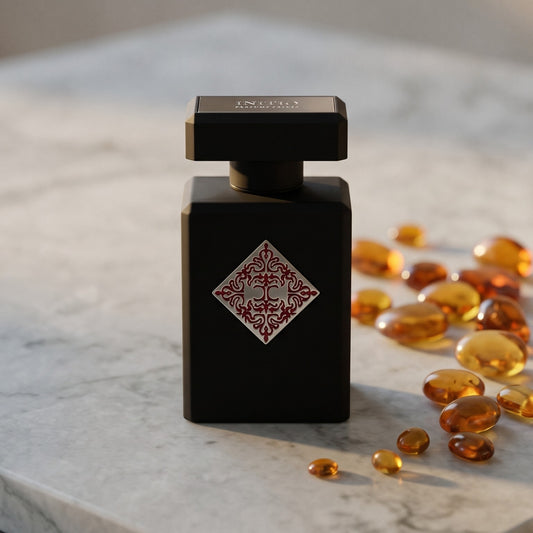 Initio Mystic Experience EDP on pale grey marble with amber resin beads scattered to one side
