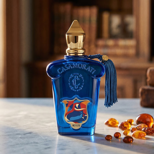 Xerjoff Casamorati Mefisto EDP on pale grey marble with amber resin beads scattered to one side