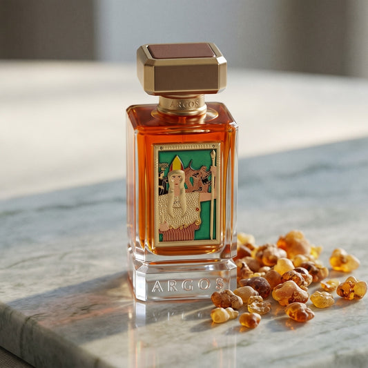 Argos Pallas Athene EDP on pale grey marble with amber resin beads scattered to one side