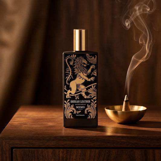 Memo Paris Iberian Leather EDP on dark walnut console with a small brass incense bowl with smoke curling upward