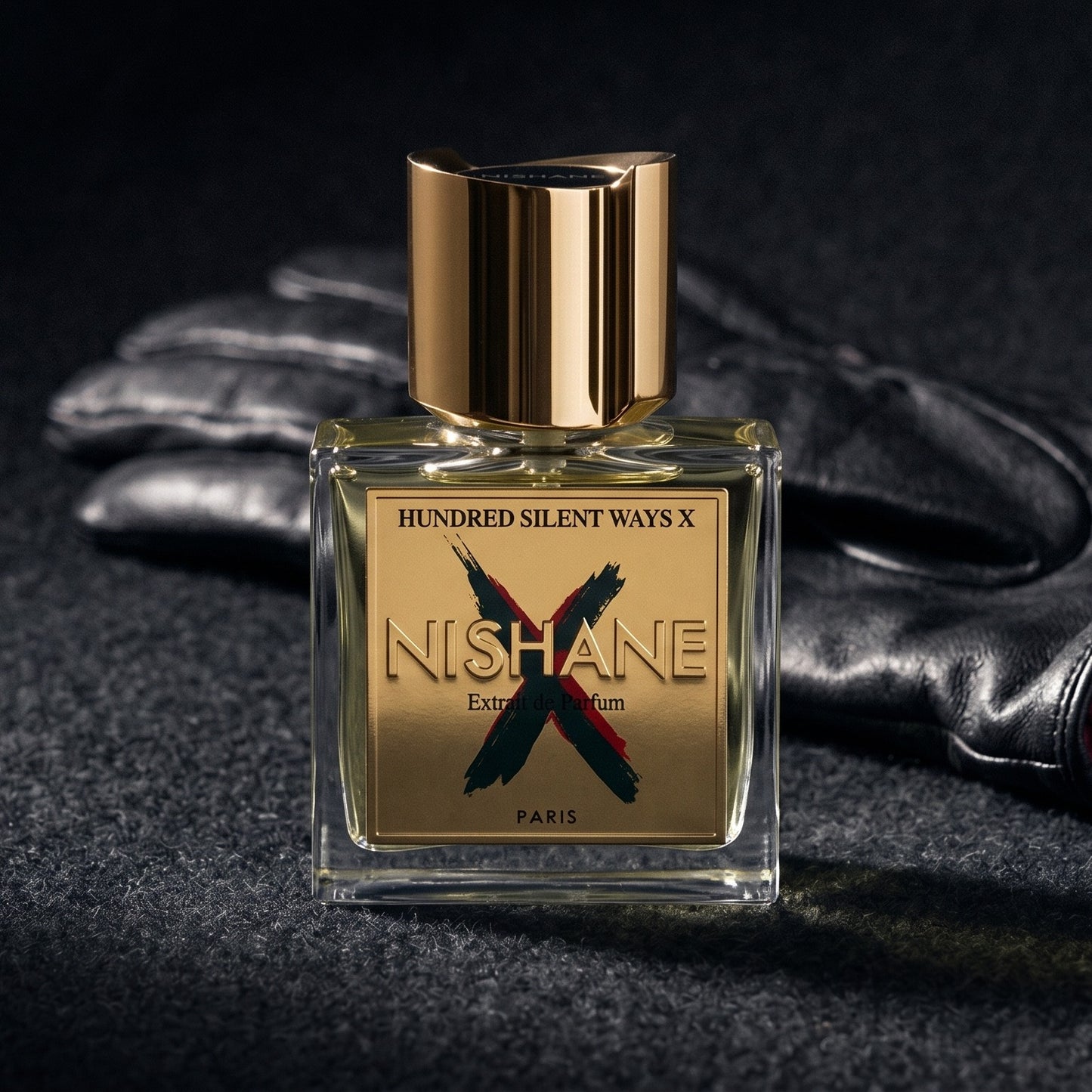 Nishane Hundred Silent Ways X Extrait on charcoal felt with a silk-lined glove just behind the bottle