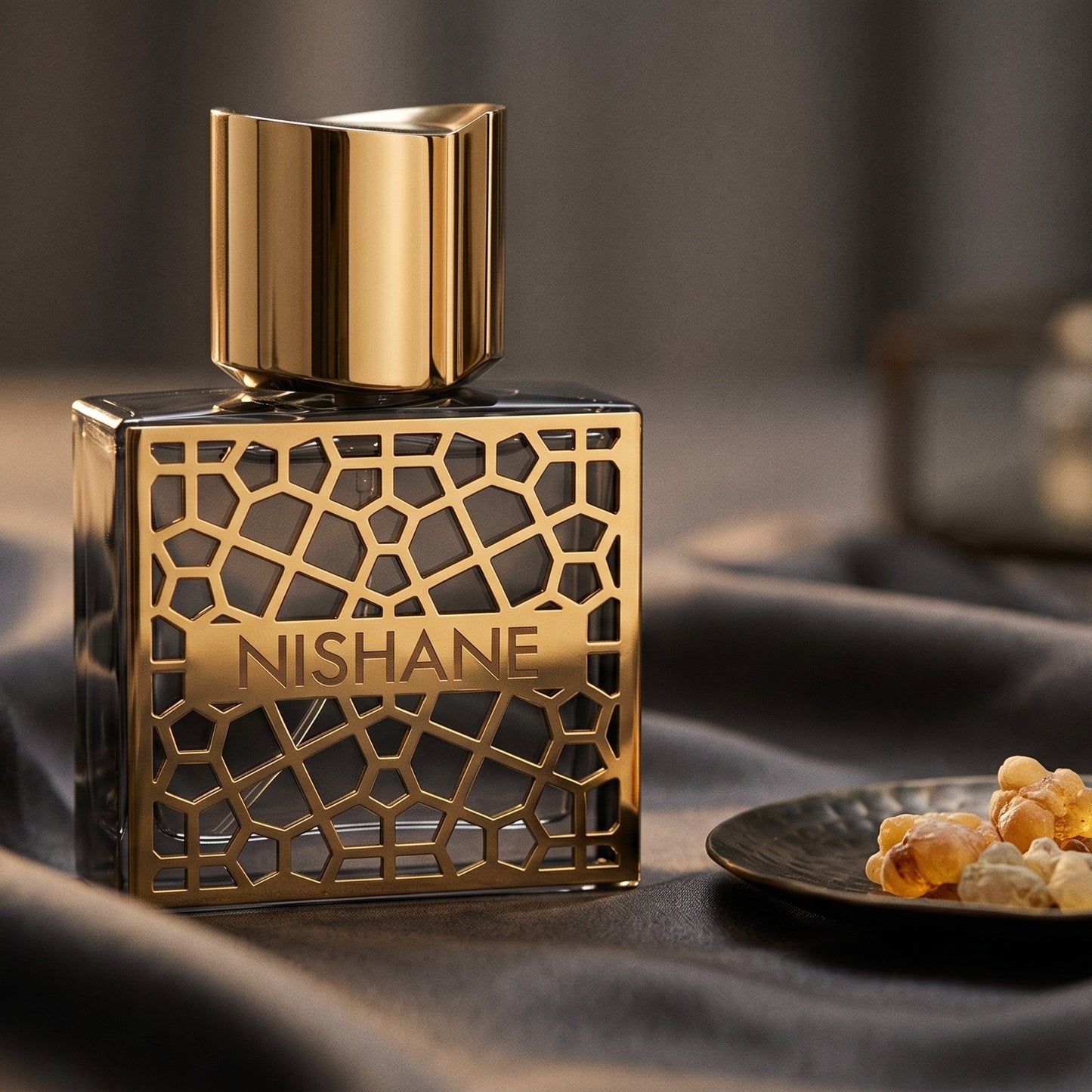 Nishane Nefs EDP on charcoal silk with frankincense resin granules in a small saucer