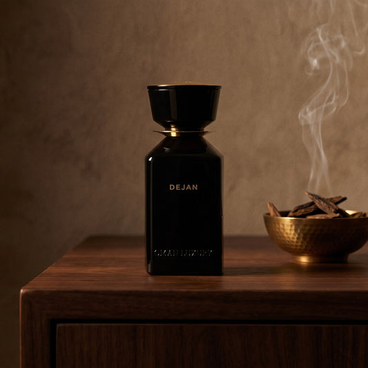 Oman Luxury Dejan EDP on dark walnut console with a small brass incense bowl with smoke curling upward