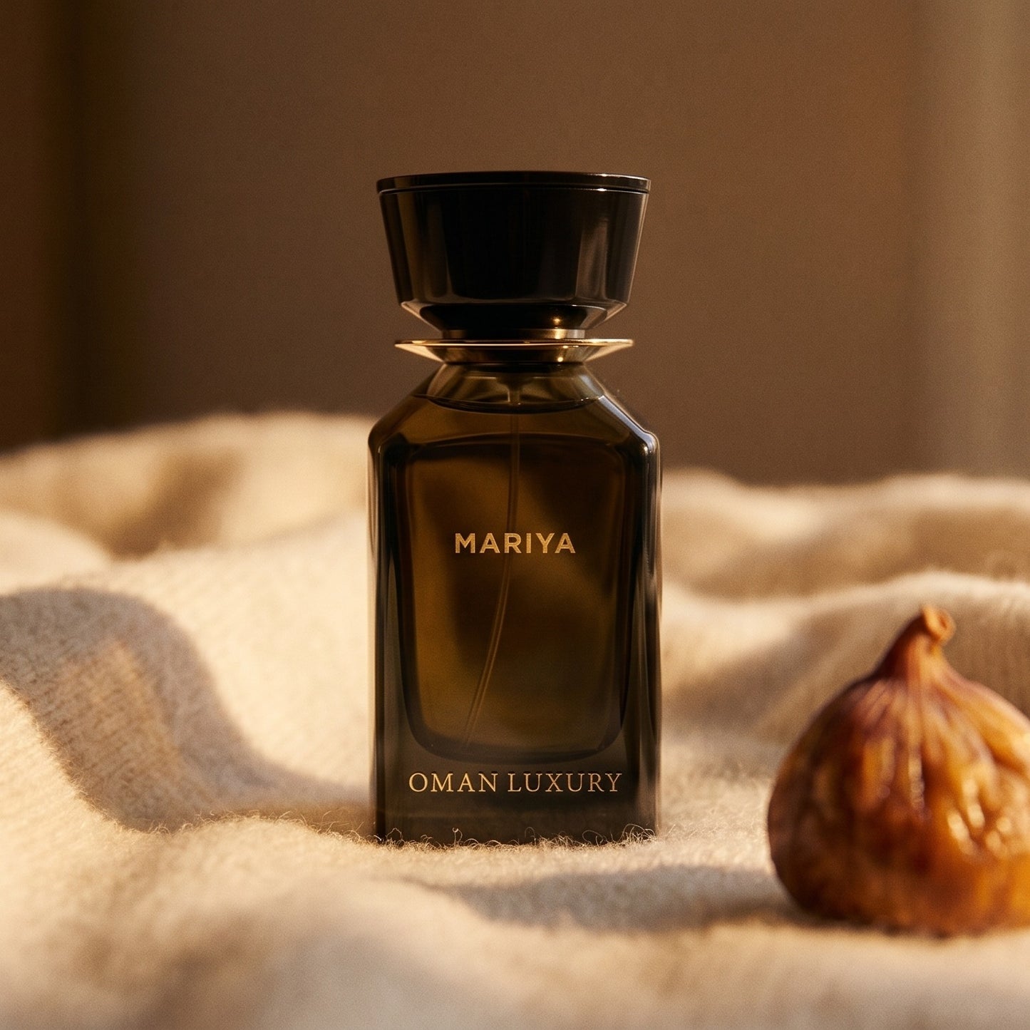 Oman Luxury Mariya EDP on cream cashmere with a single dried fig beside the bottle