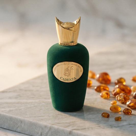 Sospiro Cadenza EDP on pale grey marble with amber resin beads scattered to one side
