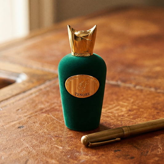 Sospiro Tenore EDP on aged cognac-leather surface with a brass fountain pen resting beside the bottle