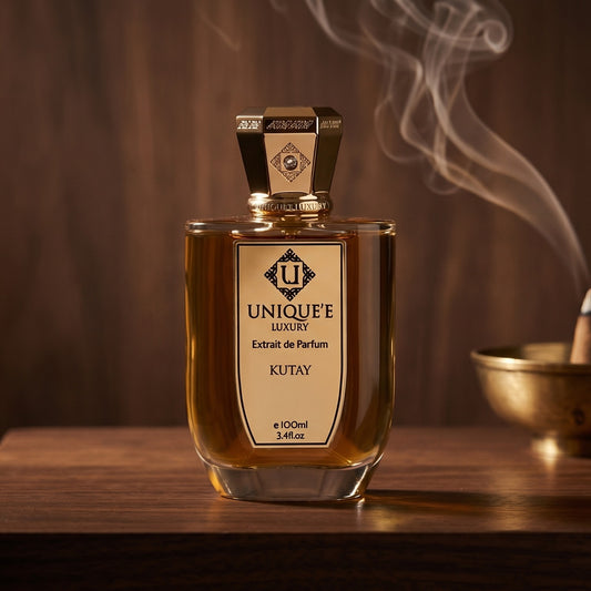 Unique Luxury Kutay Extrait on dark walnut console with a small brass incense bowl with smoke curling upward