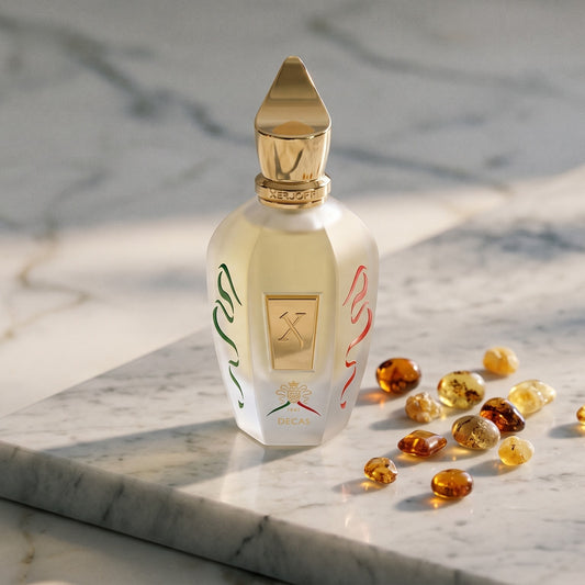 Xerjoff Decas EDP on pale grey marble with amber resin beads scattered to one side