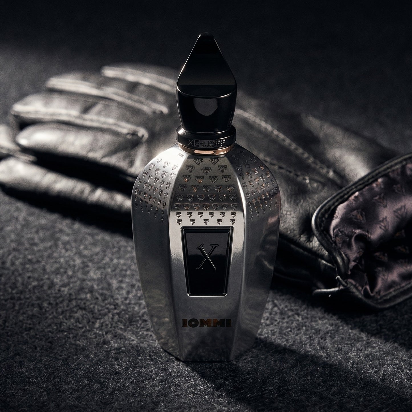 Xerjoff Monkey Special Tony Iommi EDP on charcoal felt with a silk-lined glove just behind the bottle
