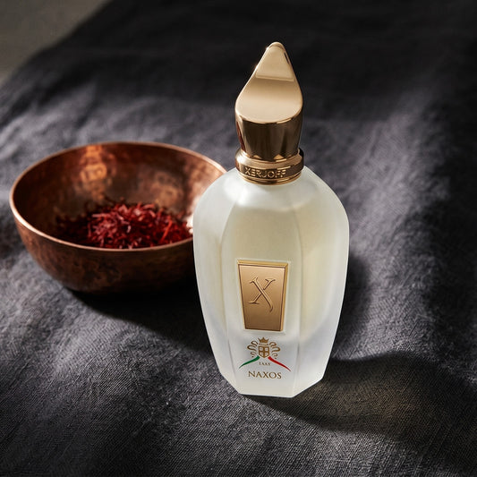 Xerjoff Naxos EDP on charcoal linen with a small copper bowl of saffron threads