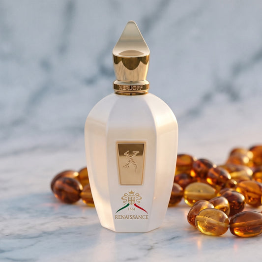 Xerjoff Renaissance EDP on pale grey marble with amber resin beads scattered to one side