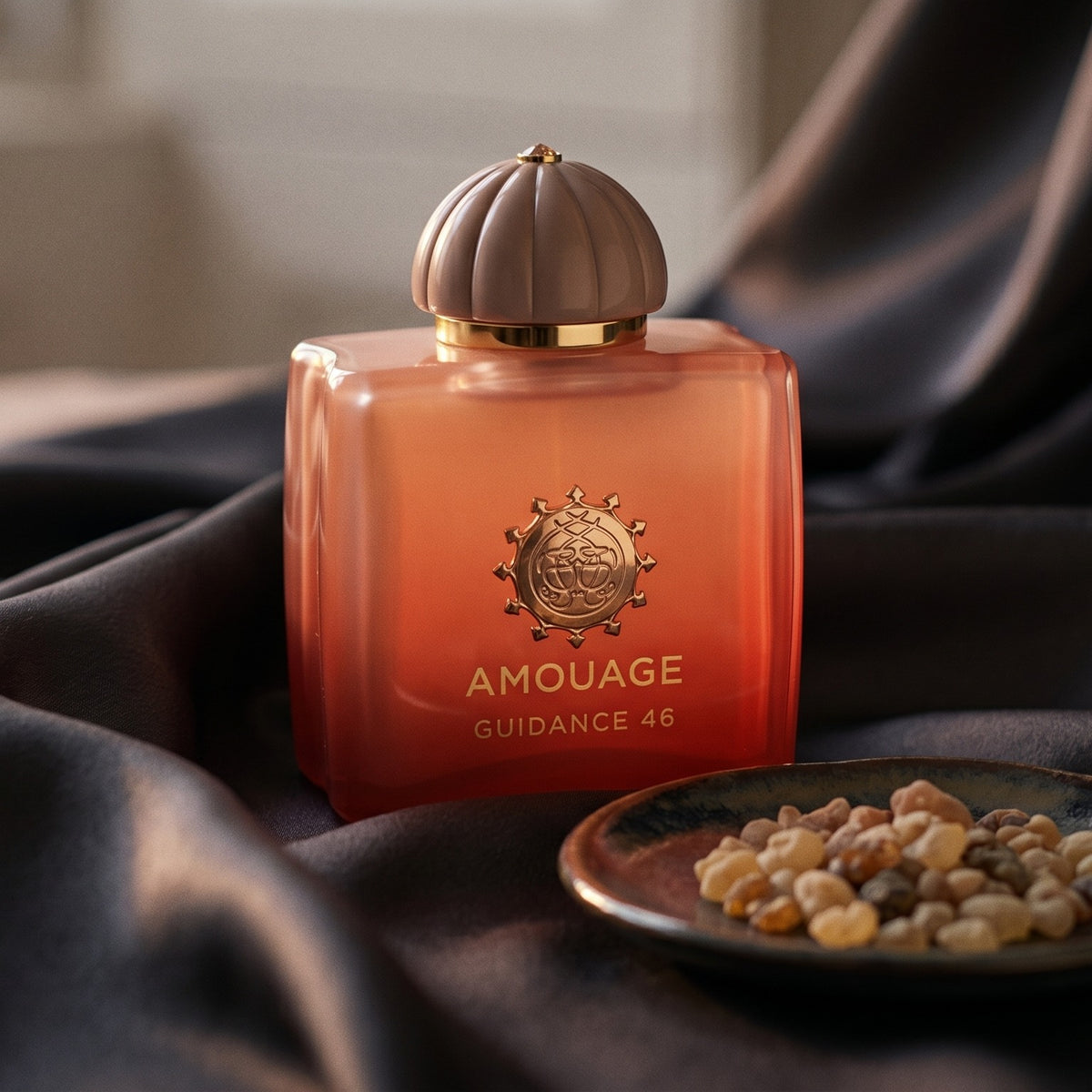 Amouage Guidance 46 EDP on charcoal raw silk with amber resin pieces near the bottle base