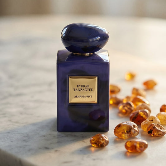 Armani/Prive Indigo Tanzanite on warm taupe marble with copal beads spilling from a small dish