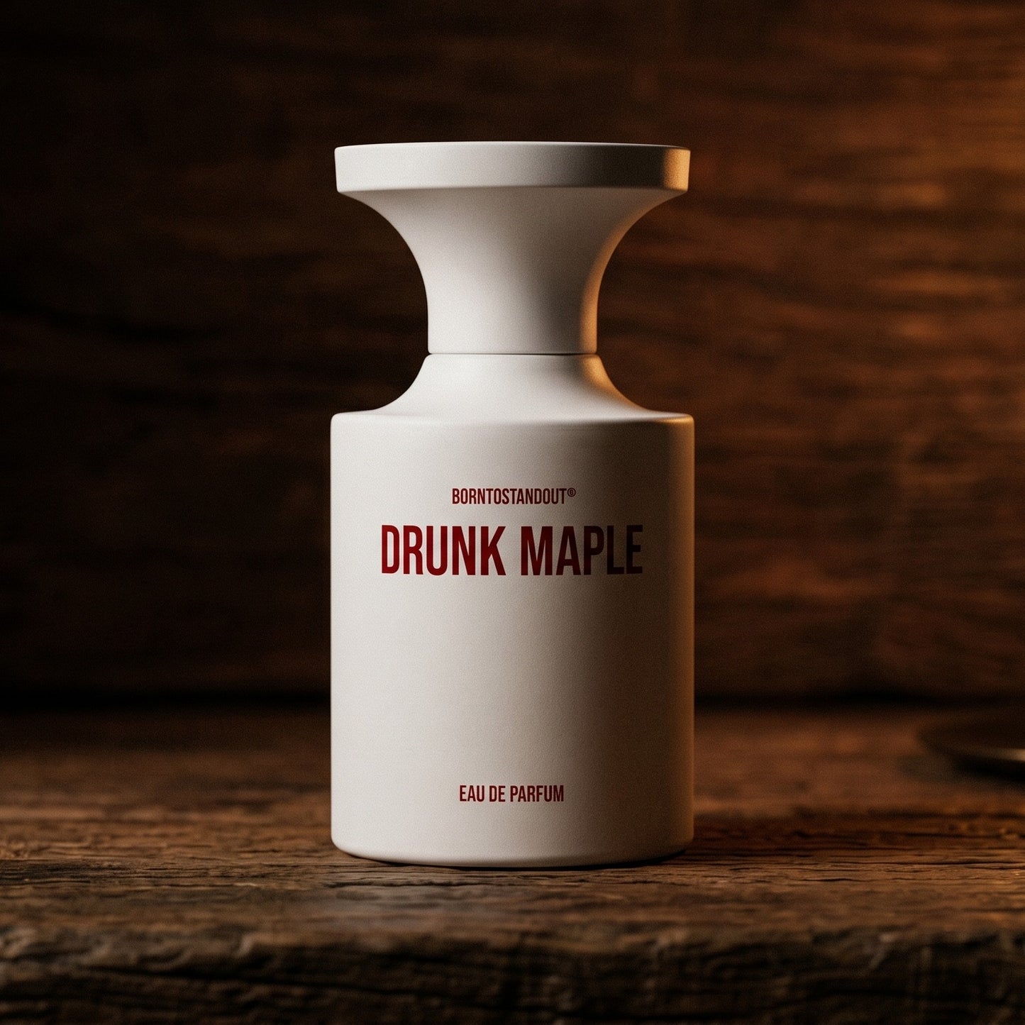 Borntostandout Drunk Maple EDP on rosewood surface with a squat brass candle flickering nearby