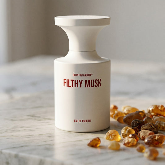 Borntostandout Filthy Musk EDP on warm ivory travertine with labdanum chunks clustered by the base