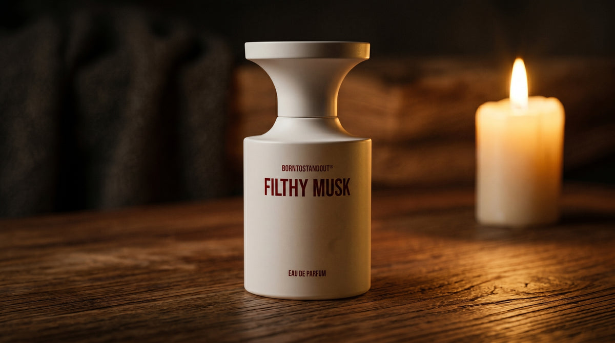 Borntostandout Filthy Musk EDP on aged teak with a candle burning gently to frame-right