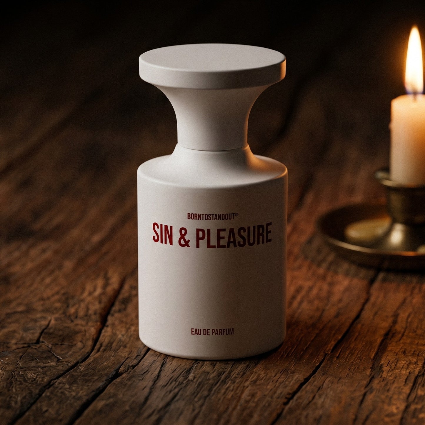 Borntostandout Sin & Pleasure EDP on aged teak with a candle burning gently to frame-right