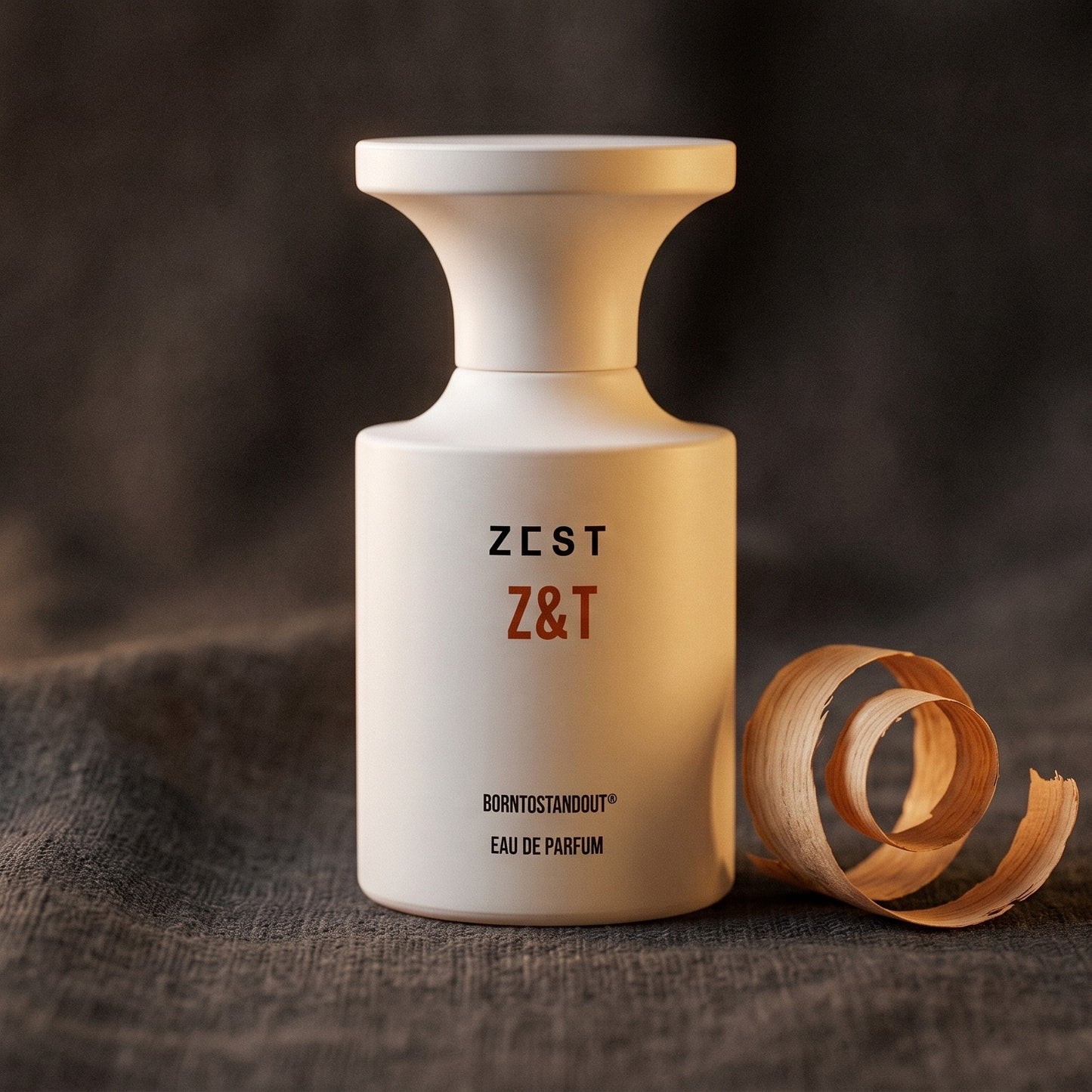 Borntostandout Z&T EDP on charcoal linen with a curl of cedarwood shaving beside the bottle