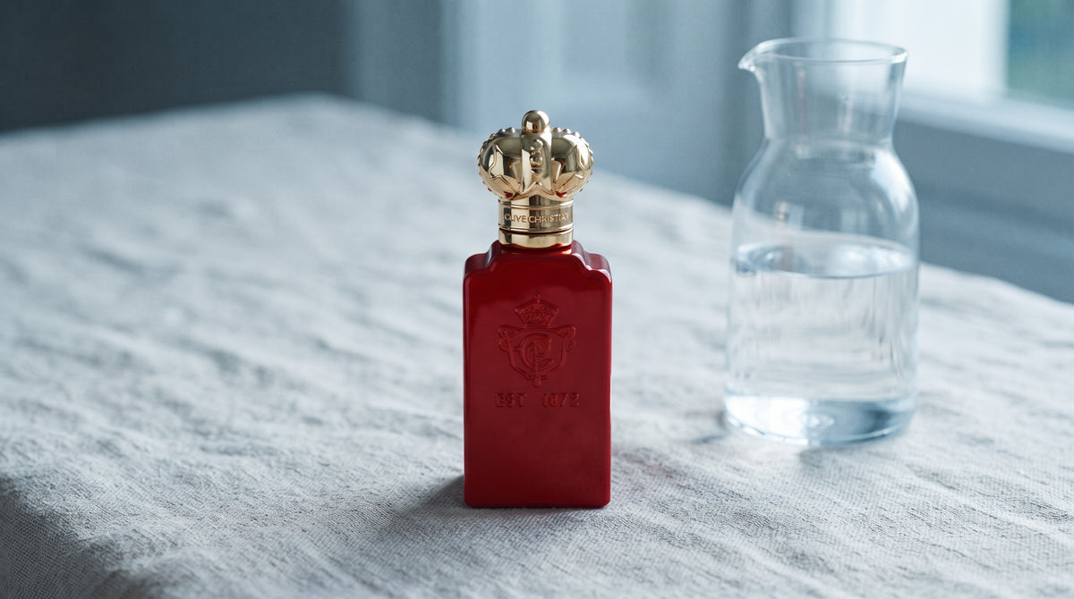 Clive Christian Crab Apple Blossom EDP on raw linen, sun-bleached with a glass carafe of water catching light
