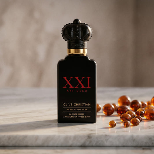 Clive Christian XXI Blonde Amber on pale grey marble with amber resin beads scattered to one side
