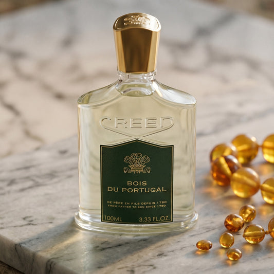 Creed Bois de Portugal on pale sandstone with golden amber shards catching the light
