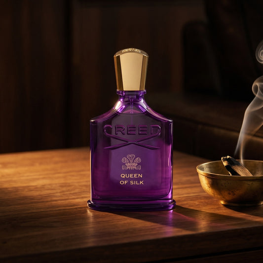 Creed Queen of Silk EDP on aged walnut board with dried agarwood shavings scattered loosely