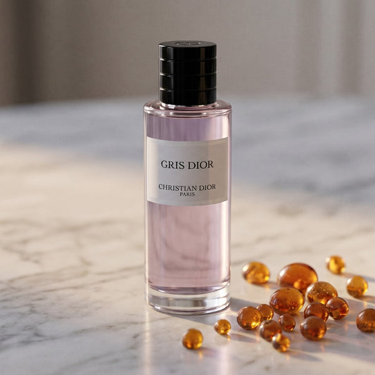 Dior Gris Dior EDP on cream stone with a scatter of honey-colored ambergris flakes