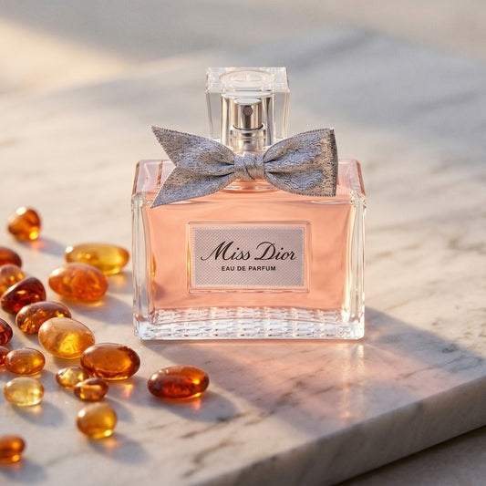 Dior Miss Dior on pale grey marble with amber resin beads scattered to one side