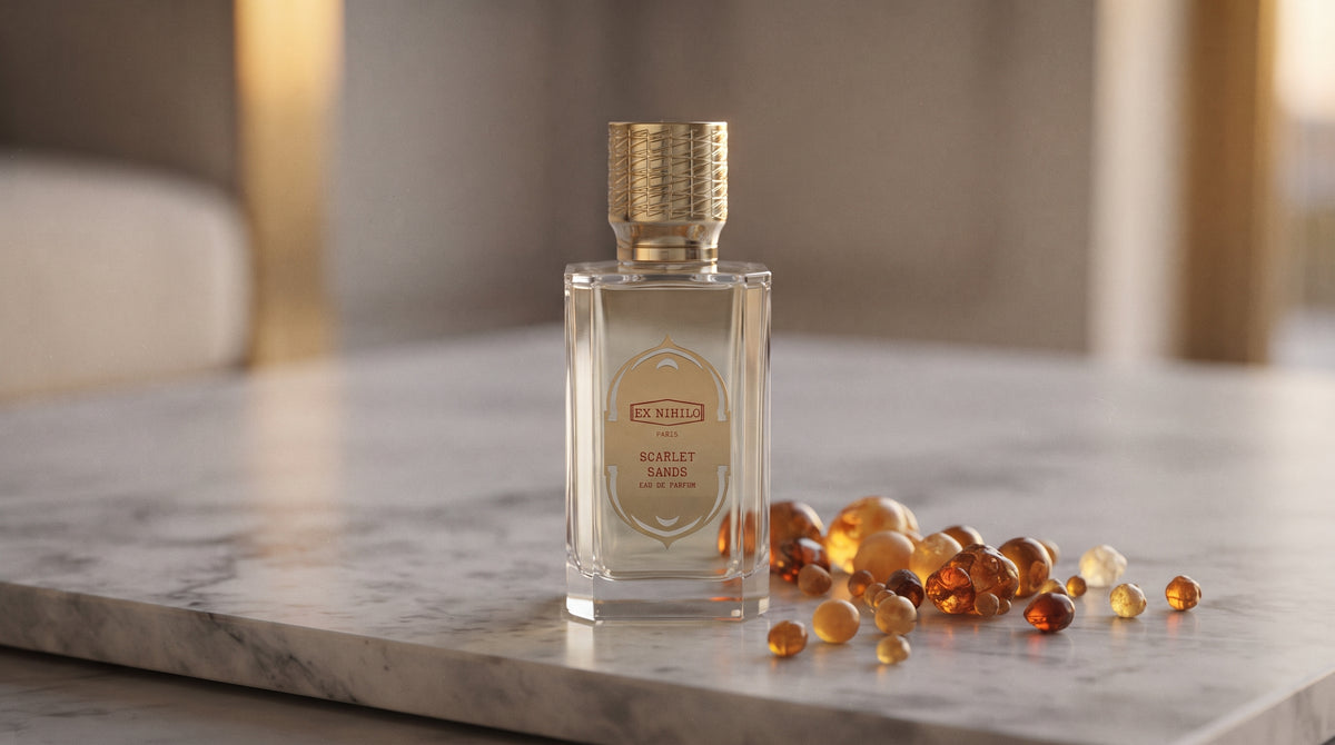 Ex Nihilo Scarlet Sands EDP - Dubai Exclusive on pale grey marble with amber resin beads scattered to one side