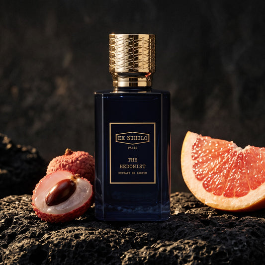 Ex Nihilo The Hedonist Extrait de Parfum on rough black volcanic stone with lychee and pink grapefruit