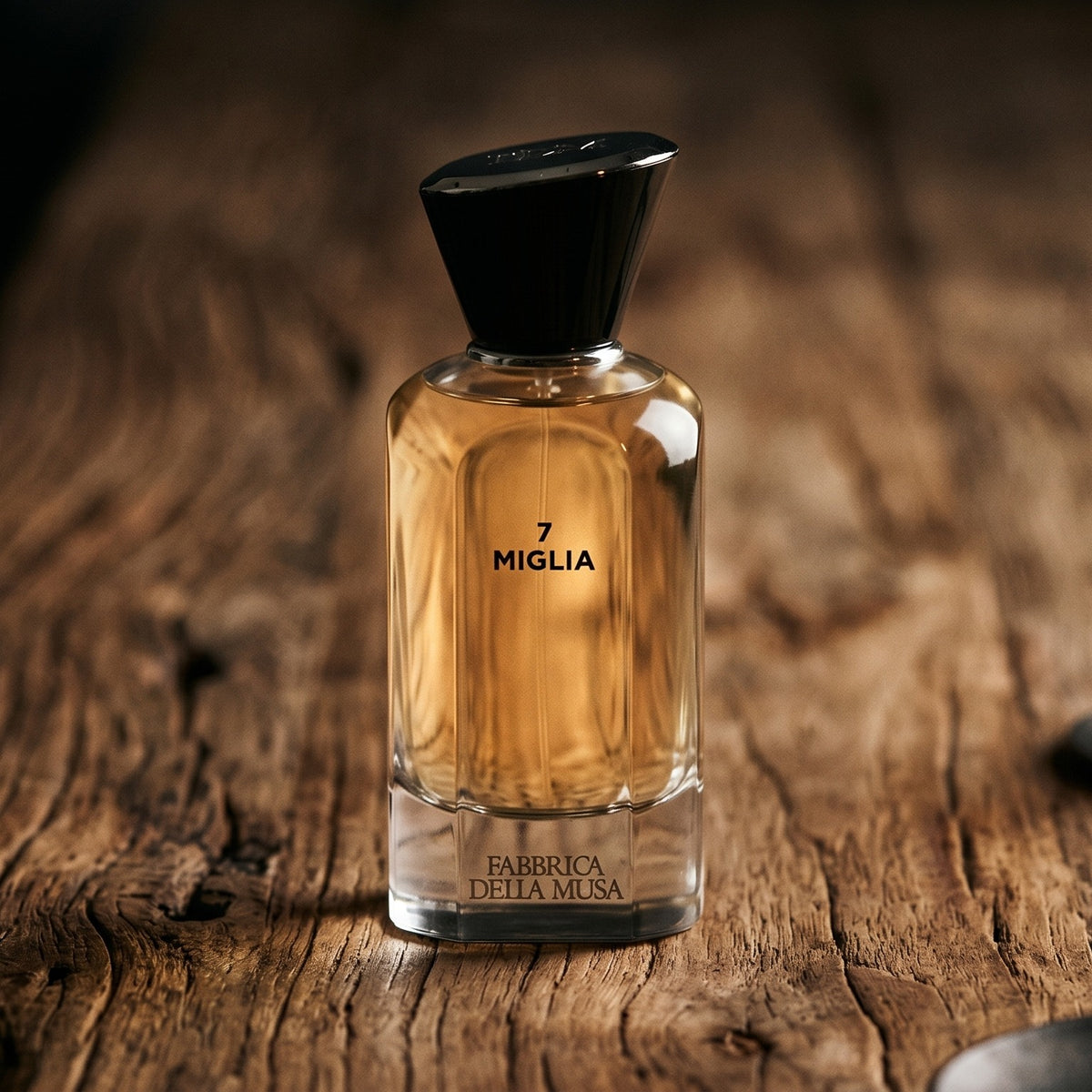 Fabbrica Della Musa 7 Miglia EDP on aged maple with a slender candlestick and drifting smoke