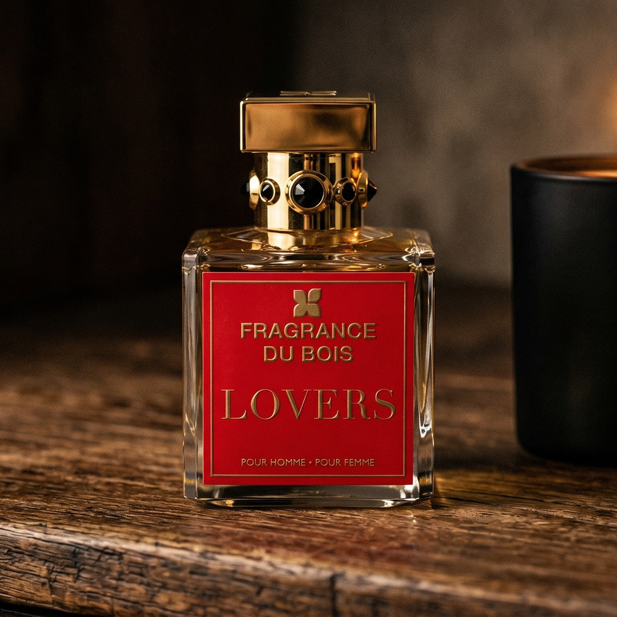Fragrance Du Bois Lovers on dark cherrywood with a tall beeswax taper casting warm light