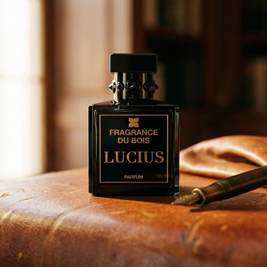 Fragrance du Bois Lucius Parfum on worn tobacco leather desk with a leather-bound notebook lying open