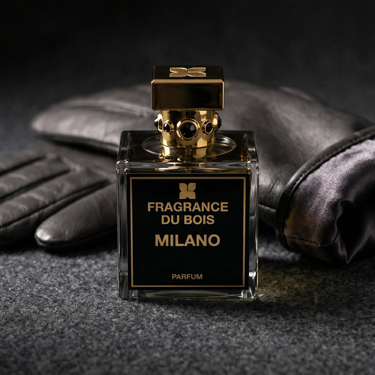 Fragrance Du Bois Milano on charcoal felt with a silk-lined leather glove placed behind the bottle