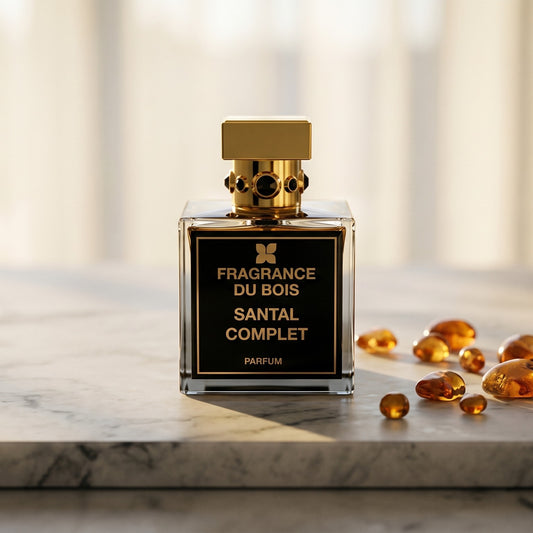 Fragrance Du Bois Santal Complet Parfum on warm taupe marble with copal beads spilling from a small dish