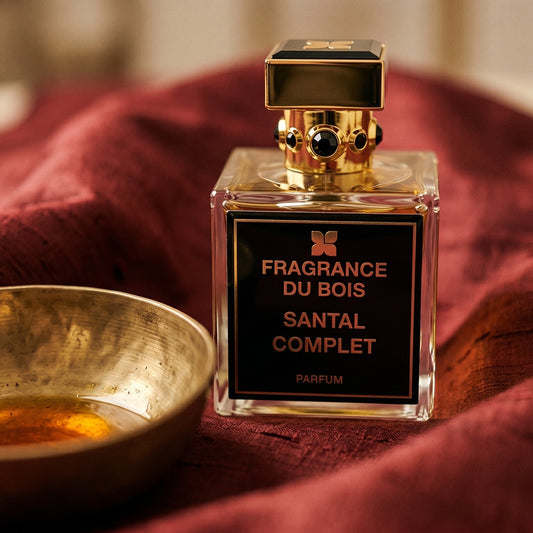 Fragrance du Bois Santal Complet Parfume on amber-toned satin with a gold-rim ceramic dish of labdanum