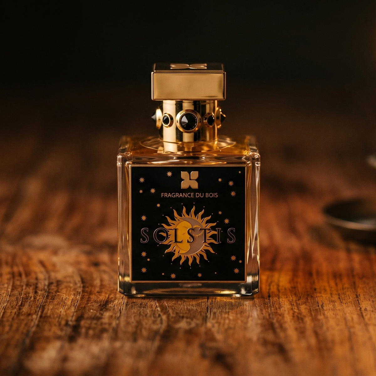 Fragrance Du Bois Solstis on reclaimed oak surface with a glass hurricane lamp softly glowing