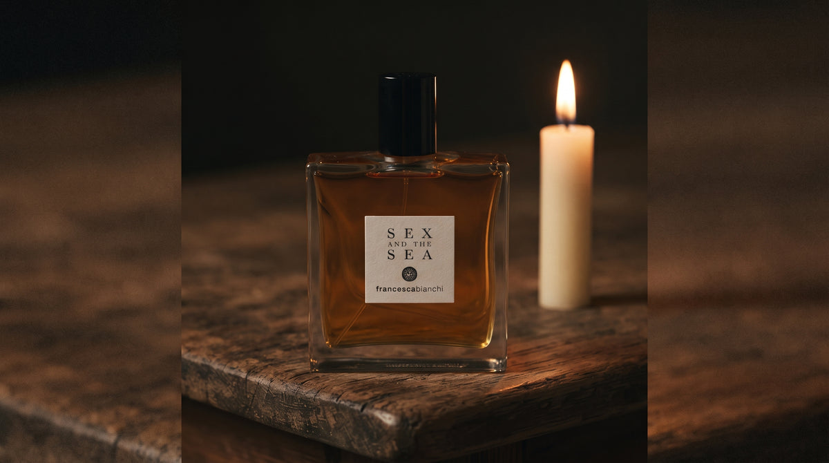 Francesca Bianchi Sex and the Sea EDP on aged teak with a candle burning gently to frame-right