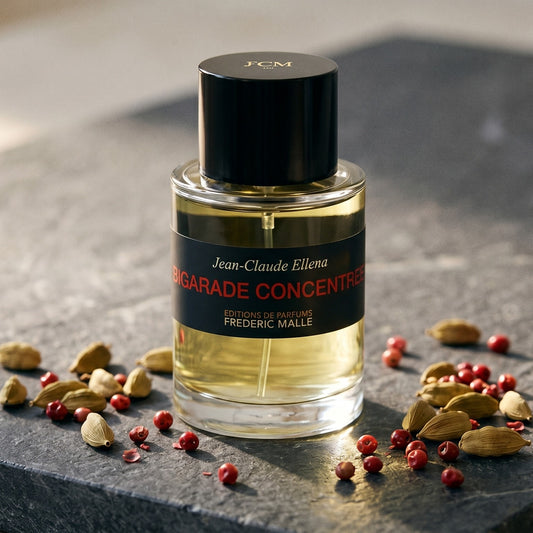 Frederic Malle Bigarade Concentree EDT on charcoal-toned marble with ground turmeric in a brass spoon