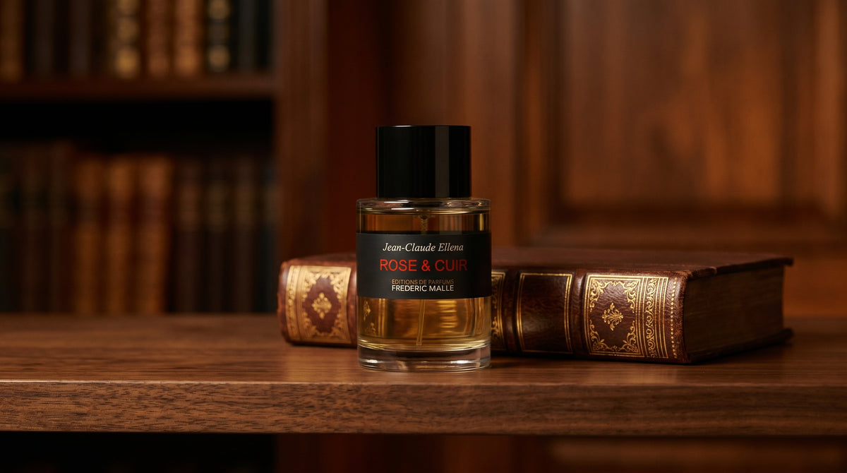 Frederic Malle Rose & Cuir EDP on dark walnut library shelf with a leather-bound book with gold foil