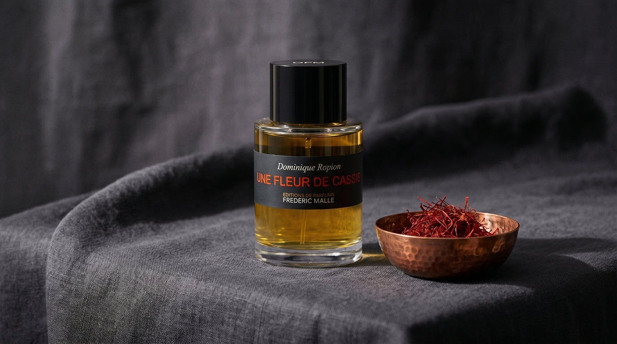 Frederic Malle Une Fleur De Cassie EDP on charcoal linen with a small copper bowl of saffron threads