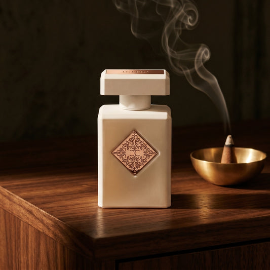 Initio Paragon on dark walnut console with a small brass incense bowl, smoke curling upward