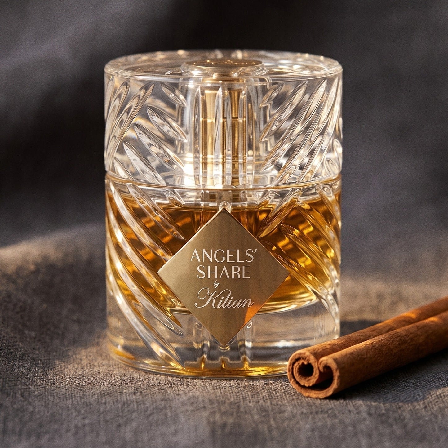 Kilian Angels Share EDP on charcoal linen with a cinnamon stick