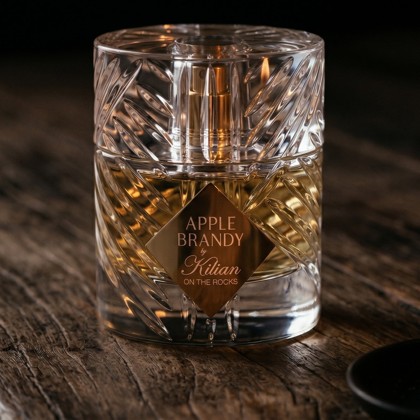 Kilian Apple Brandy on the Rocks on walnut side table with a pair of lit votives beside the bottle