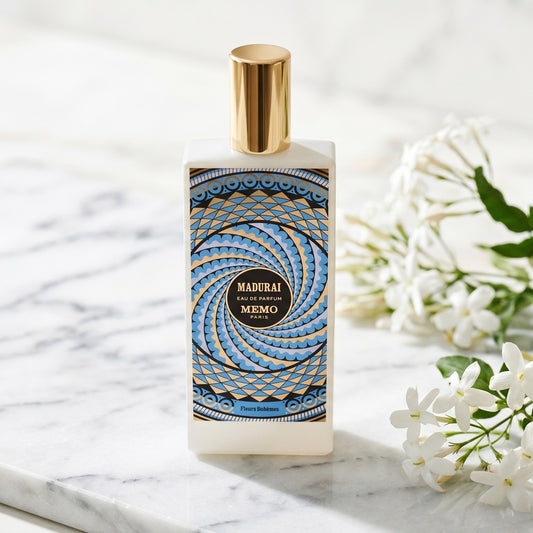 Memo Paris Madurai EDP on white carrara marble with jasmine sprigs placed to frame-right