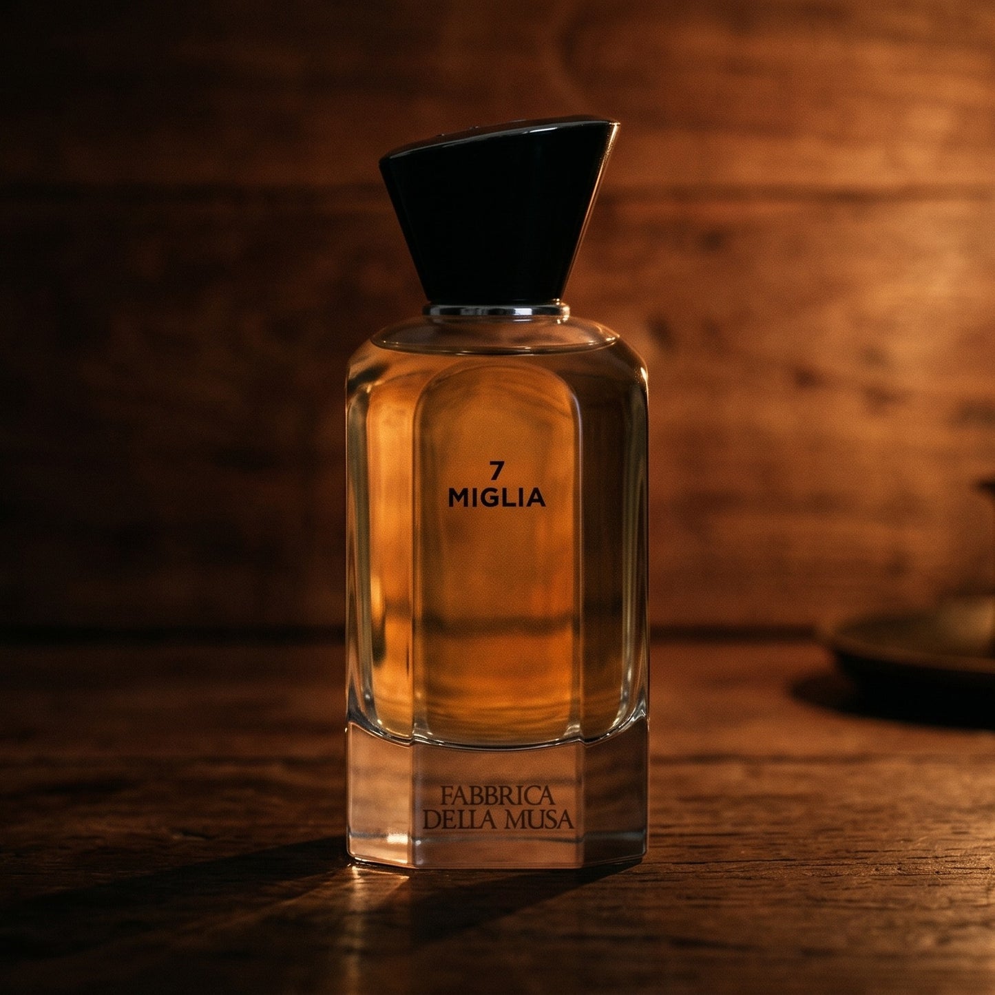 Miglia Fabbrica della Musa EDP on walnut side table with a pair of lit votives beside the bottle