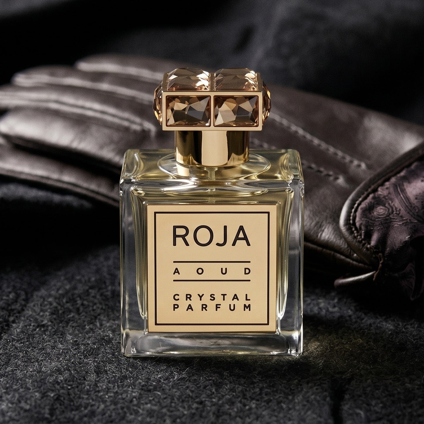 Roja Aoud Crystal Parfum on smoke-grey wool with a folded pair of driving gloves to the side