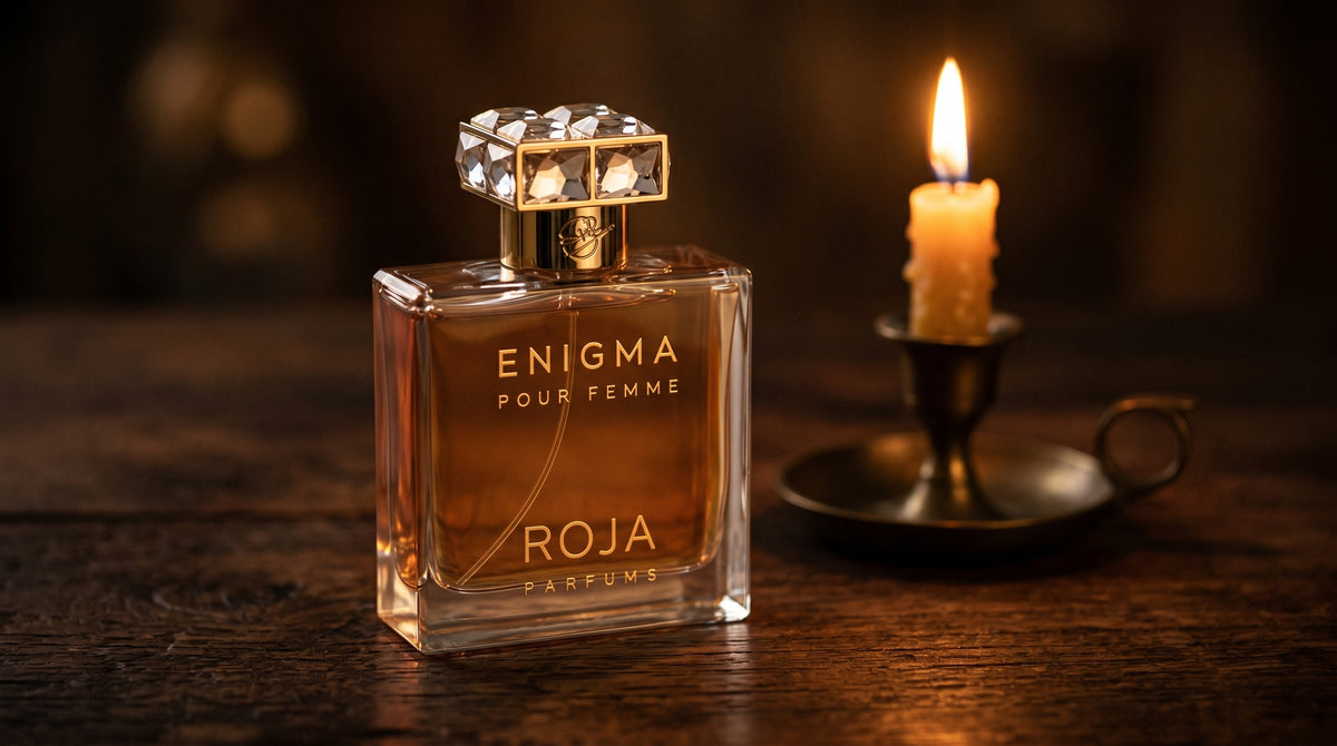 Roja Enigma Pour Femme Parfum on aged teak with a candle burning gently to frame-right