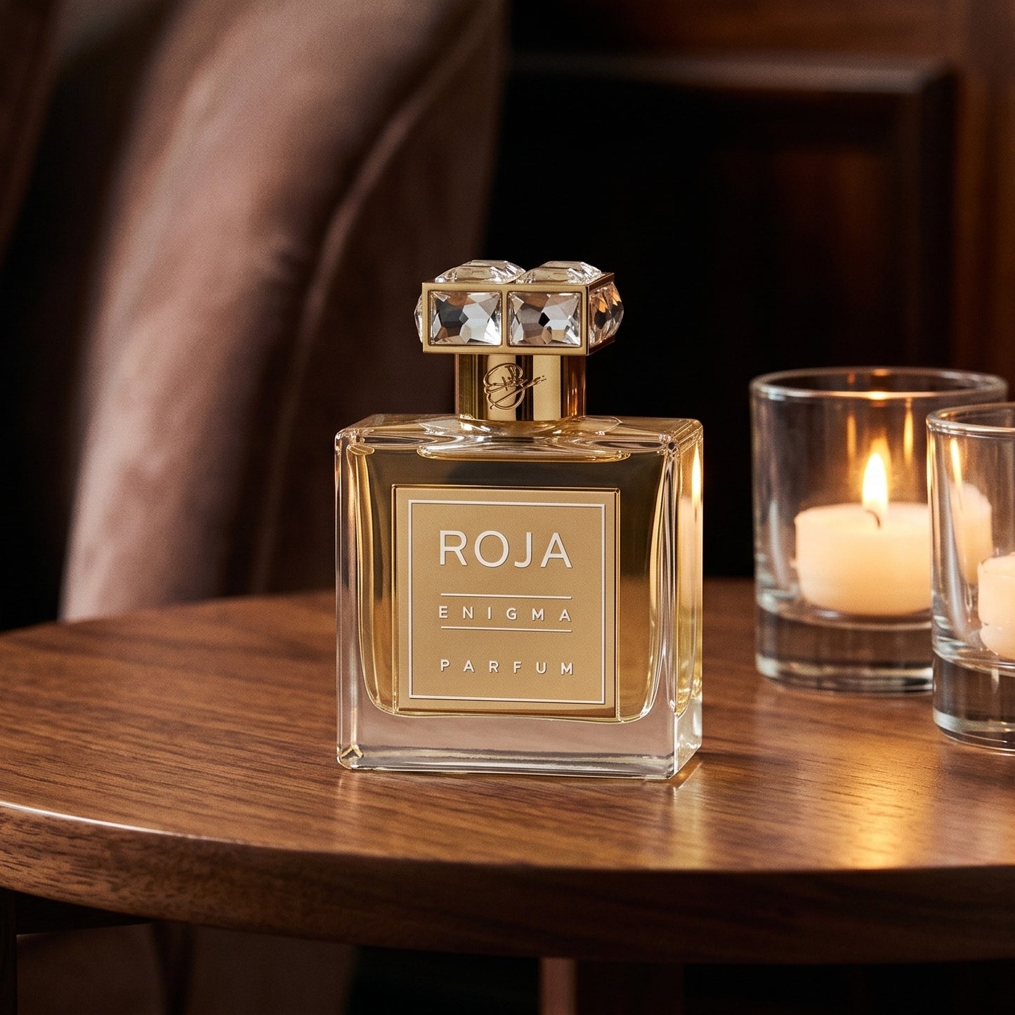 Roja Enigma Pour Femme Parfum on walnut side table with a pair of lit votives beside the bottle