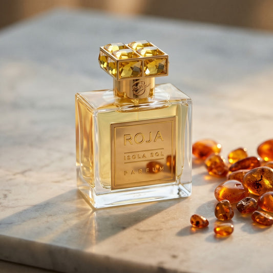 Roja Isola Sol Parfum on warm taupe marble with copal beads spilling from a small dish